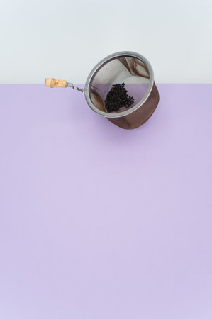 metal tea strainer on a lilac tabletop background with text spaceの写真素材
