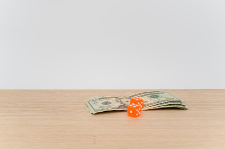 US dollar currency banknotes and dice on a wooden background with copy spaceの写真素材