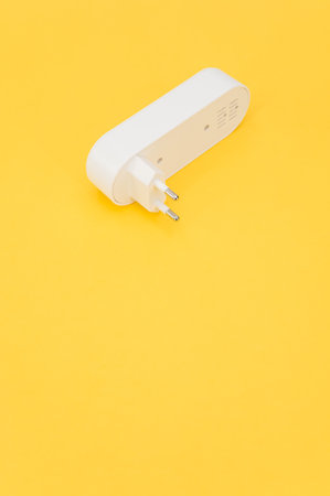 isolated plug in electronic pest killer device in a plastic package on a yellow worktop