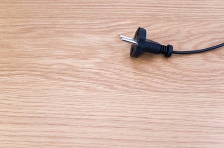 isolated electrical power cord and plug on a wooden background with copy spaceの写真素材