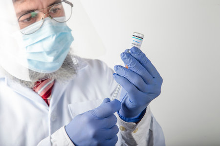 Close up of a competent doctor prepares the vaccine before injectionの写真素材