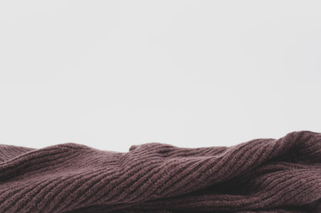isolated dark brown knitted cloth on a white tabletop with text spaceの写真素材