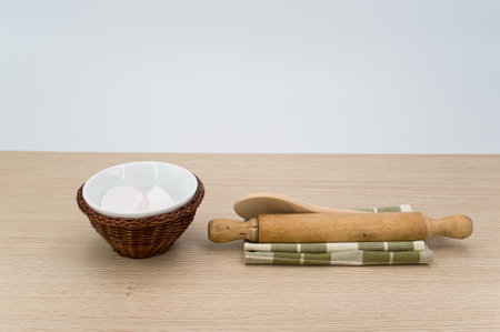 natural wood kitchen utensils and a table napkin on a wooden background with copy space
