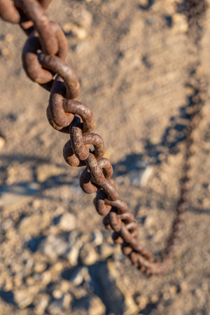 rusty chain hanging down cutting the passage with out-of-focus background