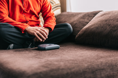 Unrecognizable man with headphones listening to music at home. Relaxed man listening to music on the sofa at home.の写真素材