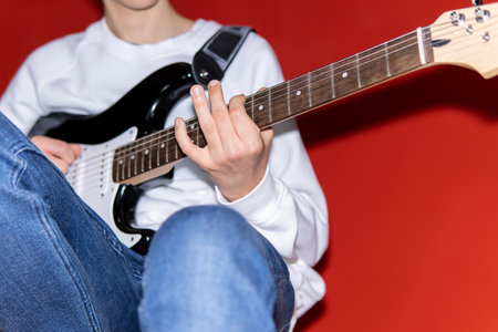 Young man playing electric guitar. Music, instrument education, entertainment, rock star, music concert and learning conceptの写真素材