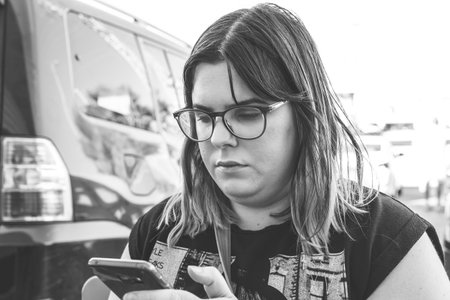 Woman using smartphone on the street. Close up black white image.の写真素材