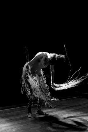 Contemporary dancer dancing in theater with black background and straw accessory. Salvador Bahia Brazil.の写真素材