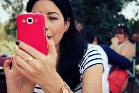 Woman taking picture with her cell phone.