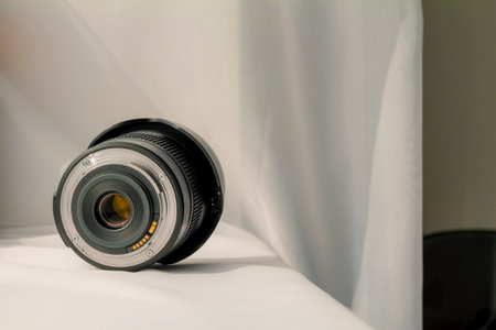 Black camera zoom lens on white cloth.
