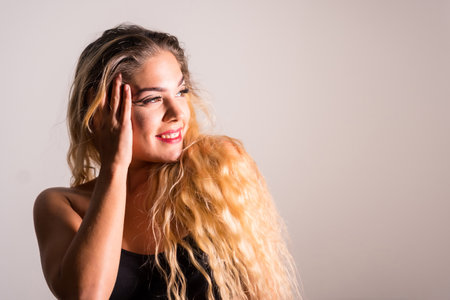 Portrait of a Caucasian blonde girl with eye drawing makeup, groomed eyelashes on a white background with a set of studio shadowsの写真素材