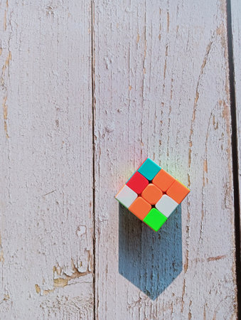 A unsorted puzzle-box in sunlight. The object is placed in a wooden surface and the sunlight created a triangular top shadowの写真素材