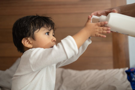 Mexican baby putting on body creamの写真素材