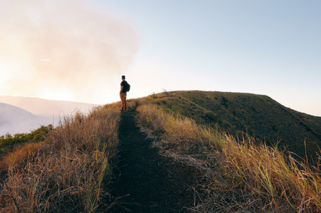A latin man standing on trail watching the beautiful view at sunset in masaya volcano national park, Nicaragua, central americaの写真素材