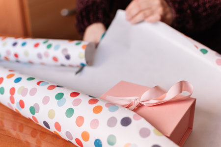 Woman wrapping a Christmas gift. Unrecognizable woman wrapping and decorating a Christmas gift.の写真素材