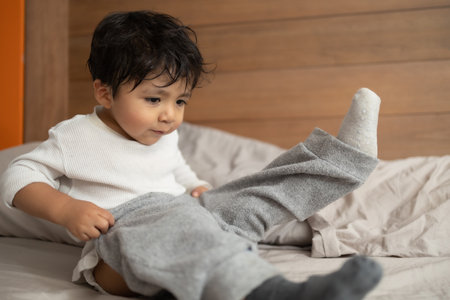 mexican 2 years old baby learning to dress up after showerの写真素材