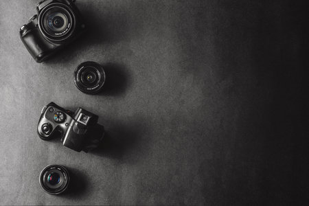 Professional cameras with different lenses on a black background.