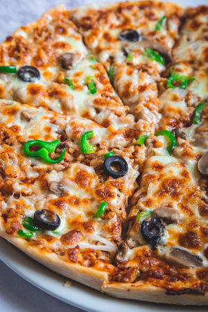 Pizza with meat, green peppers, mozzarella cheese, mushrooms and black olives.