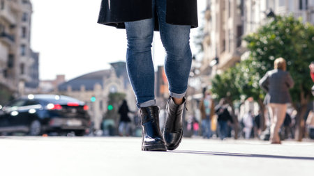 Beautiful and young elegant woman walking with coffee in hand through the city on a sunny day. Elegant young women conceptの写真素材