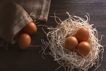 Eggs in the nest . On the wooden table. Healthy food.の写真素材