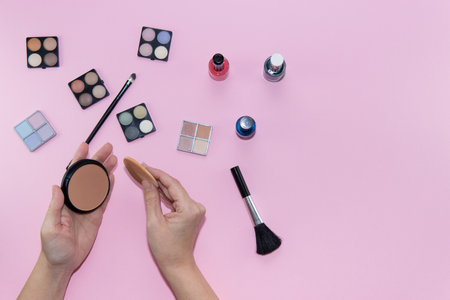 Cosmetic set on pastel pink background. Woman hands holding a make-up cotton. Beauty conceptの写真素材