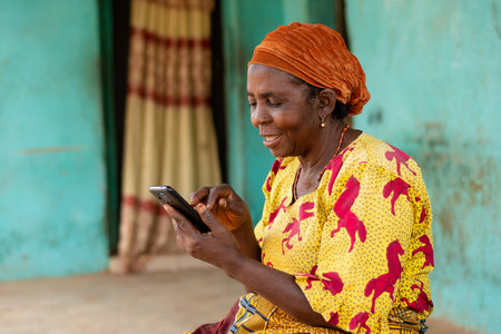happy elderly african woman using her mobile phoneの写真素材