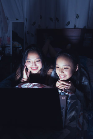 Young women at a sleepover watching movies.の写真素材