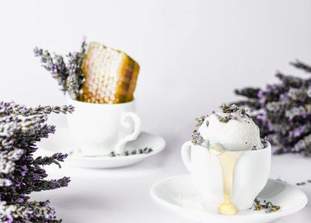 lavender honey ice cream in a coffee cup, lavender flowers, honey honeycombs, white background, high keyの写真素材