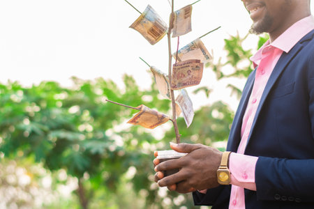 man holding a money tree outsideの写真素材