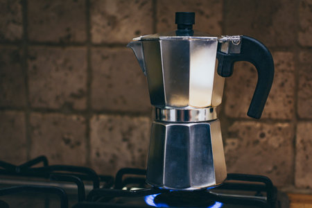 Italian traditional moka pot coffee maker on a gas stove. Close-up and detail.の写真素材