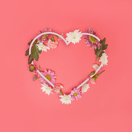 Heart-shaped copying space decorated with various real flowers. Spring concept on a pastel background. Valentine or female background design day. Symbol of a happy anniversary. Minimum flat birth.の写真素材
