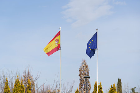 European and Spanish flag in park with trees, Madrid, Spainの写真素材