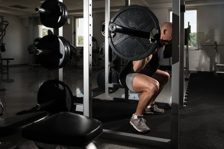 Man Working Out Legs With Barbell In A Gym - Front Squat Exercise