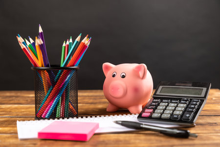 piggy bank with calculator and pencilsの写真素材