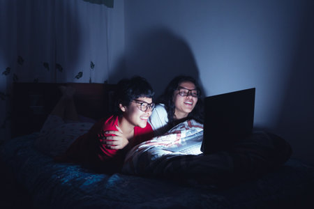 Young women at a sleepover watching movies.の写真素材