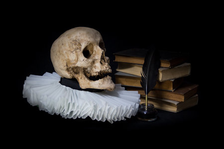 Books with a quill, inkwell, skull and gola .on dark background concept of universal literatureの写真素材