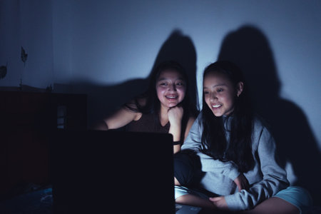 Young women at a sleepover watching movies.の写真素材