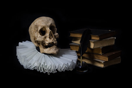 Books with a quill, inkwell, skull and gola .on dark background concept of universal literatureの写真素材