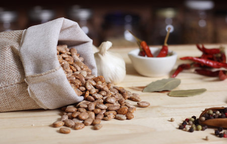 Burlap Sack of Pinto Beans on Table with Spices in Background Shalloe DOF