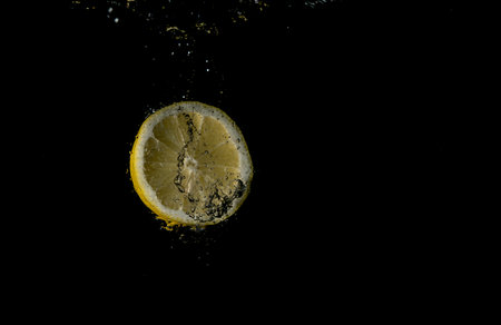 lemon falling in water with splash on black background. with bubbles
