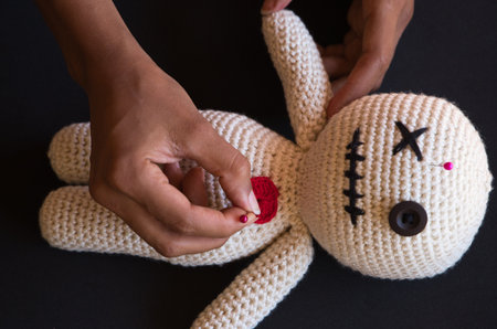 details of a witch woman doing voodoo on a doll. You can see how she sticks needles in the doll. Witchcraftの写真素材