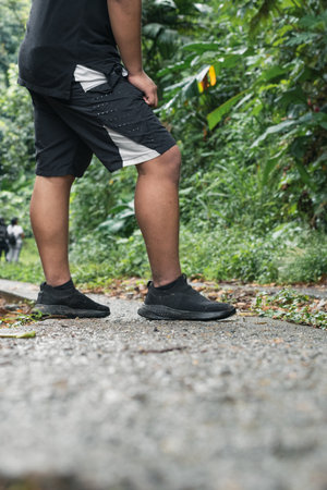 shot of the feet of a young man resting in the middle of the road after walking a long trail. boy...