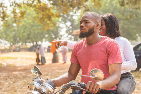 african woman on a bike showing the rider direction to takeの写真素材