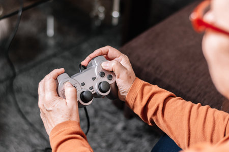 Unrecognizable woman playing video game console. Mature Caucasian woman playing video game console.