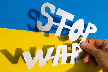 Stop war, conflict between Ukraine and Russia. A woman's hands holding a cutout made by hand with a slogan to stop the warの写真素材