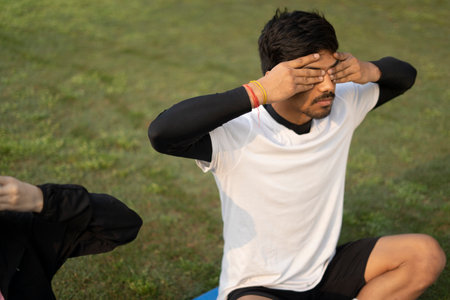 An indian young couple doing yoga early in the morning, boy and girl doing yoga in the park.Healthy...