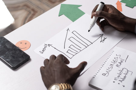 african businessman draws up a graph and plan