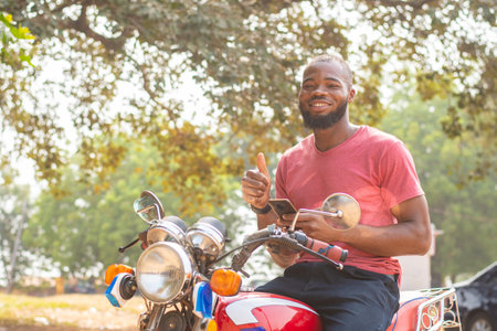 okada rider using his phone, thumbs up gestureの写真素材