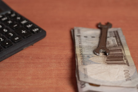 spanner placed on top of some money