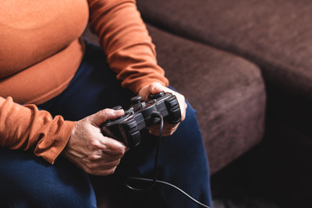 Unrecognizable woman playing video game console. Mature Caucasian woman playing video game console.